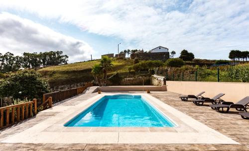 una piscina en un patio con sillas y una casa en Pensua Roncudo, en Corme-Aldea