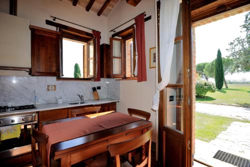a kitchen with a wooden table and a window at I Casali Della Ghisleria in Ospedalicchio