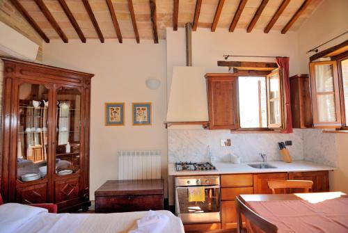 a kitchen with wooden cabinets and a stove top oven at I Casali Della Ghisleria in Ospedalicchio
