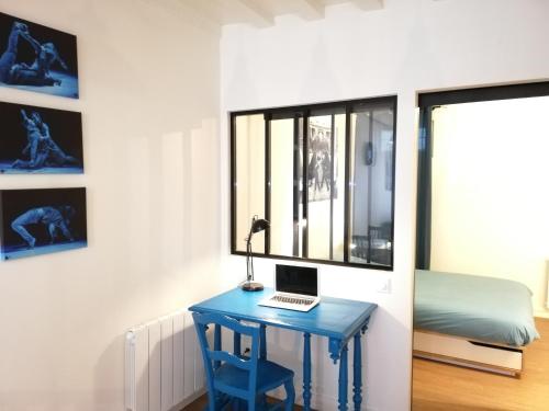 una scrivania blu con un computer portatile sopra accanto a una finestra di Welk'Home Loft Rouen CHU - Coeur Historique a Rouen