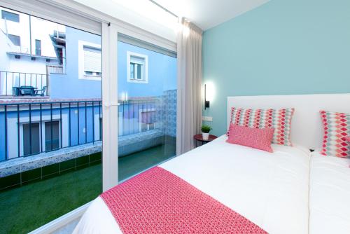 a bedroom with a white bed and a balcony at ABAL Apartments - Barrio in Alicante