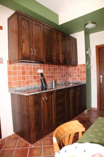 a kitchen with wooden cabinets and a sink at VACACIONAL LA TEA THE BEST LOCATION and THE BEST VIEWS in Tejeda
