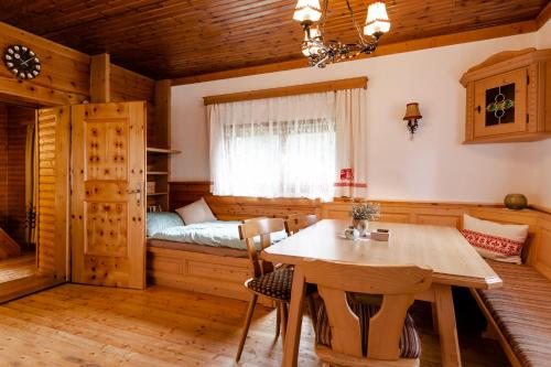 a dining room with a table and a bed at Moosbacher-Hütte in Aichberg