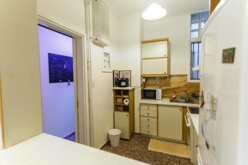 a small kitchen with a sink and a door at Peonios Apartment in Athens