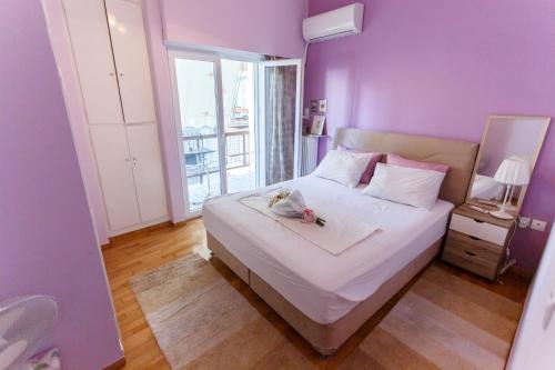a purple bedroom with a bed with a stuffed animal on it at Peonios Apartment in Athens