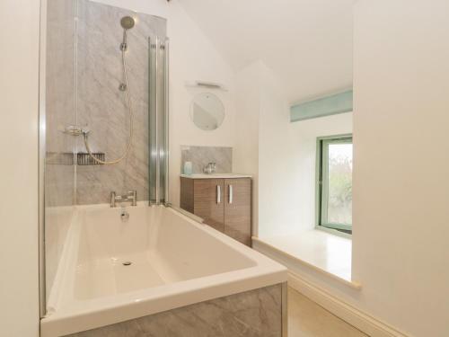 a white bathroom with a tub and a window at Dale Barton in Wells