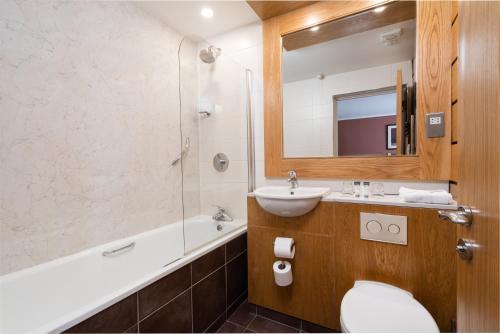 a bathroom with a sink and a toilet and a mirror at Strangford Arms Hotel in Newtownards
