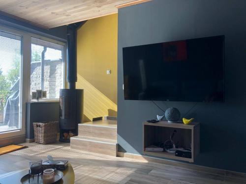 a living room with a large flat screen tv on a wall at NGI Vacances in Malmedy