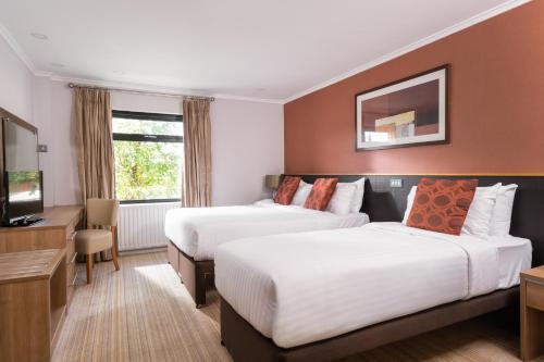 a hotel room with two beds and a television at Strangford Arms Hotel in Newtownards