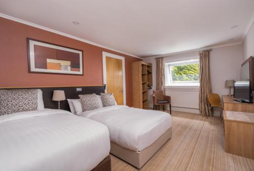 a hotel room with two beds and a television at Strangford Arms Hotel in Newtownards