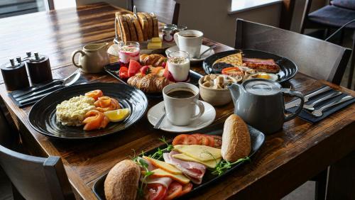 a table with plates of breakfast food on it at Bosville Hotel in Portree