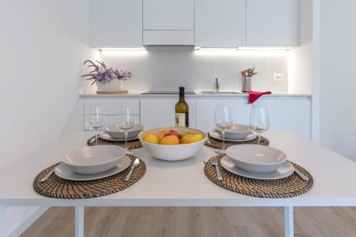 a table with a bowl of fruit and wine glasses at Residence La Torre in Trieste