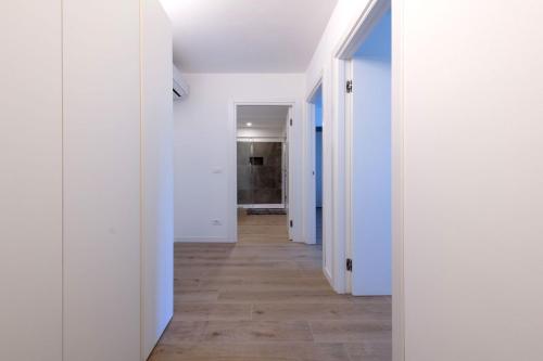 an empty hallway with white walls and wood floors at Residence La Torre con private park in Trieste