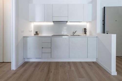a white kitchen with a sink and a refrigerator at Residence La Torre con private park in Trieste