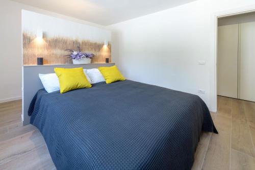 a bedroom with a large bed with yellow pillows at Residence La Torre con private park in Trieste