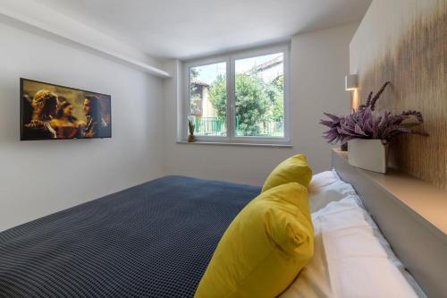 a bedroom with a bed with a yellow pillow on it at Residence La Torre con private park in Trieste