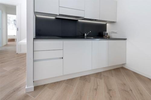 a kitchen with white cabinets and a sink at Residence La Torre con private park in Trieste