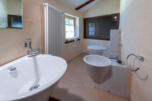 a bathroom with a white sink and a toilet at Residence La Torre con private park in Trieste