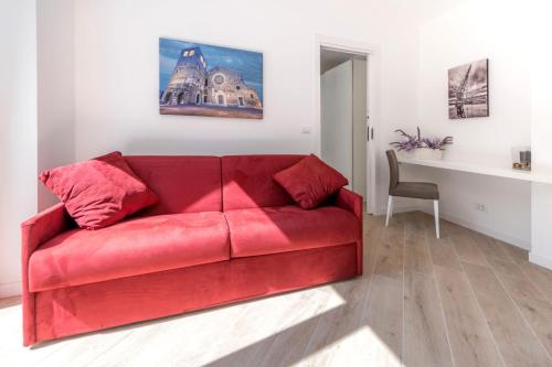 a red couch in a living room with a table at Residence La Torre con private park in Trieste