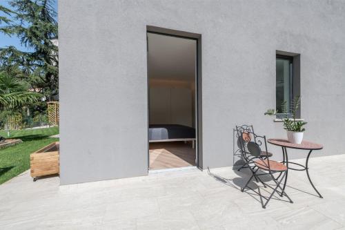 a patio with a table and a chair and a bedroom at Residence La Torre con private park in Trieste