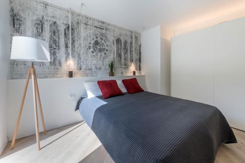 a bedroom with a bed with two red pillows at Residence La Torre con private park in Trieste