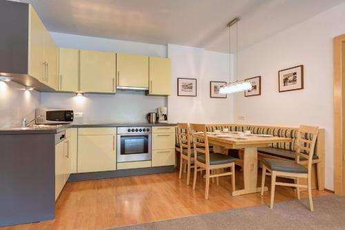 una cucina con un tavolo e una sala da pranzo di Apart La Vita a Sankt Anton am Arlberg