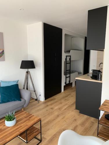 ein Wohnzimmer mit einem Sofa und einem Tisch in der Unterkunft Appartement vue mer in La Baule