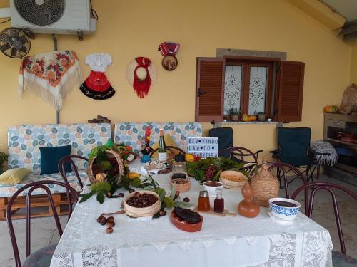 een tafel met een witte tafeldoek met voedsel erop bij Casa flor da laranjeira in Ponte de Lima