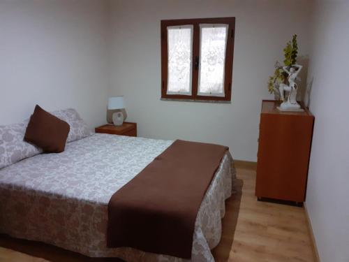 a bedroom with a bed and a window at Casa flor da laranjeira in Ponte de Lima