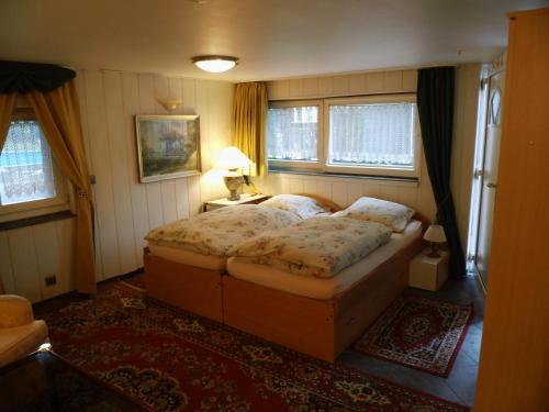 a bedroom with a large bed and two windows at Villa Bomberg in Eisenach