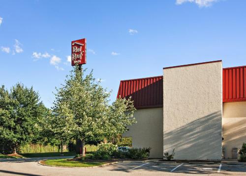 a building with a tree in front of it at Red Roof Inn Cleveland Airport - Middleburg Heights in Middleburg Heights