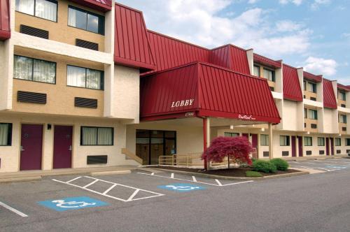 a hotel with a red roof and a parking lot at Red Roof Inn Cleveland Airport - Middleburg Heights in Middleburg Heights