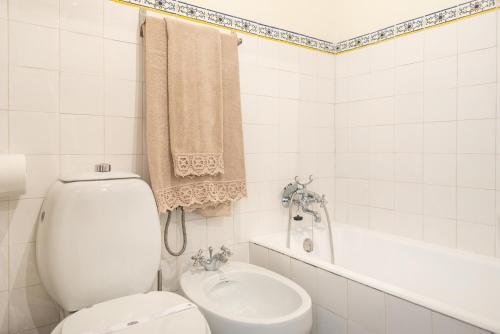 y baño con aseo, lavabo y bañera. en Quinta dos Campos - Chalé, en Braga