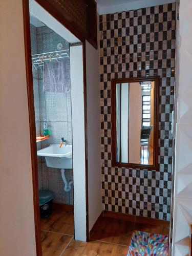 a bathroom with a sink and a mirror at Suites Oliveira in Arraial do Cabo