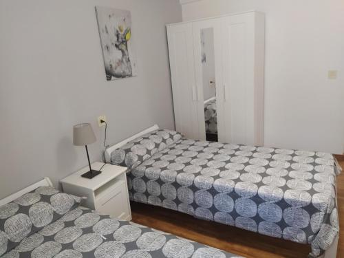 1 dormitorio con 2 camas y mesa con lámpara en Casa Rural Mizkerrenea, Ituren, Navarra, en Ituren