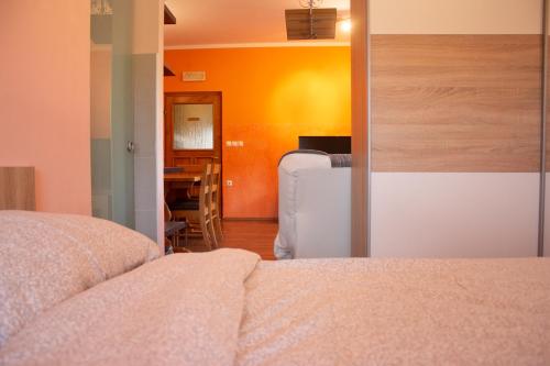 a bedroom with a bed and an orange wall at Turistična kmetija Sirk in Zgornja Velka