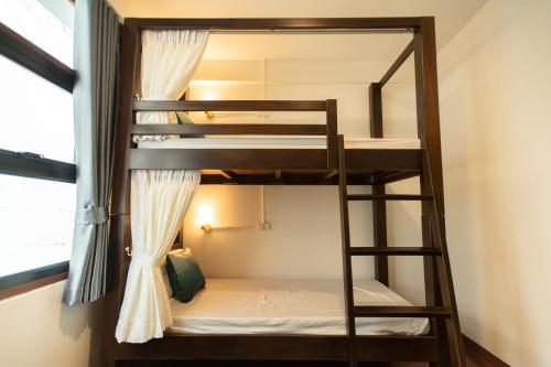 Mystay Hostel Nan في نان: سرير بطابقين في غرفة مع نافذة