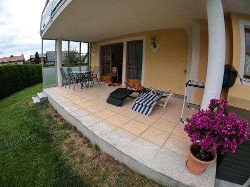 a patio with a table and chairs and flowers at Haus Hedwig in Fuschl am See