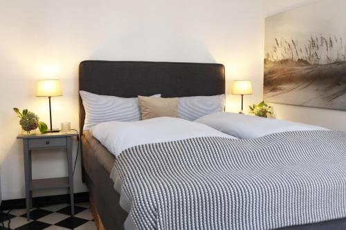 a bedroom with a large bed and two lamps at Haus Schlafgemach in Flensburg
