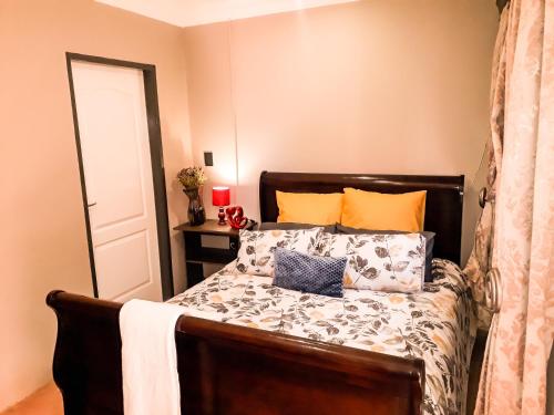 um quarto com uma cama com almofadas laranja e azul em Quiet Getaway em Bloemfontein