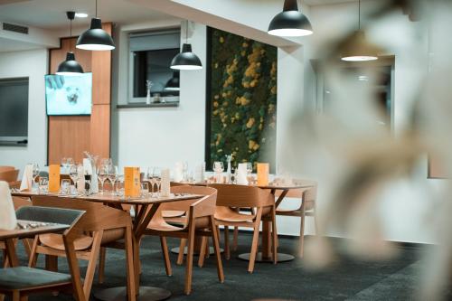 a dining room with wooden tables and chairs at Hotel Aréna in Košice