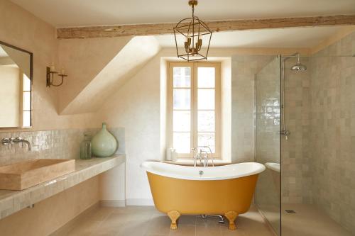 een badkamer met een groot bad en een raam bij Luxury townhouse in the heart of medieval St Paul de Vence in Saint-Paul-de-Vence