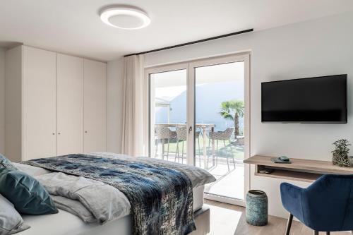 - une chambre avec un lit, une télévision et un balcon dans l'établissement Romy & Johannes Guesthouse, à Schenna