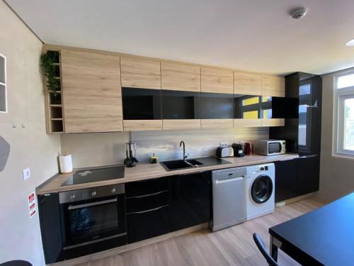 a kitchen with a sink and a washing machine at cascaischillhouse in Cascais