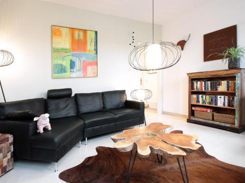 ein Wohnzimmer mit einem schwarzen Sofa und einem Holztisch in der Unterkunft Charming LOUISE in Saarbrücken