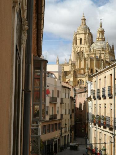 a view of the cathedral from a window of a building at Hostal Juan Bravo in Segovia