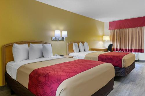 Postel nebo postele na pokoji v ubytování Jax Airport Hotel