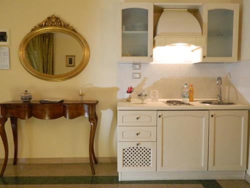 a bathroom with a sink and a vanity with a mirror at Il Campanile B&B in Pisa