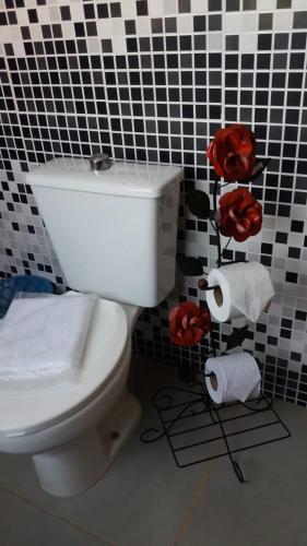 a bathroom with a toilet and two rolls of toilet paper at POUSADA CHARLOTTE in Tiradentes