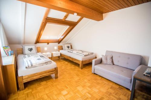 a attic room with two beds and a couch at Auszeit im Schwarzwald in Lenzkirch